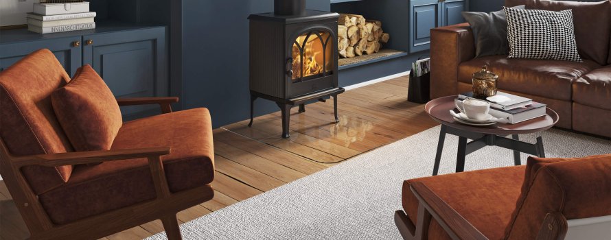 Jøtul F 200 wood stove in black cast iron in a living room with dark blue walls