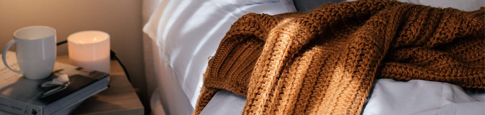 Cosy blanket and coffee cup on the bed