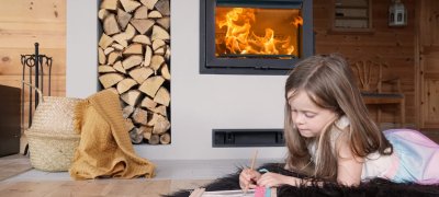 Girl sitting in front of the fireplace Jøtul I 520 FR
