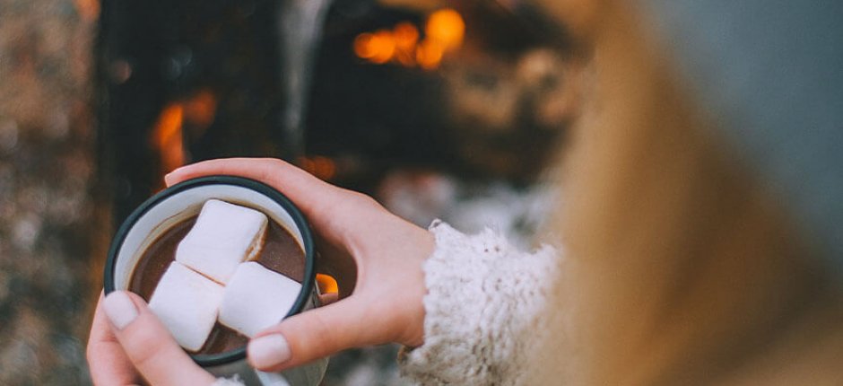 Girl drinking cocoa by the fire