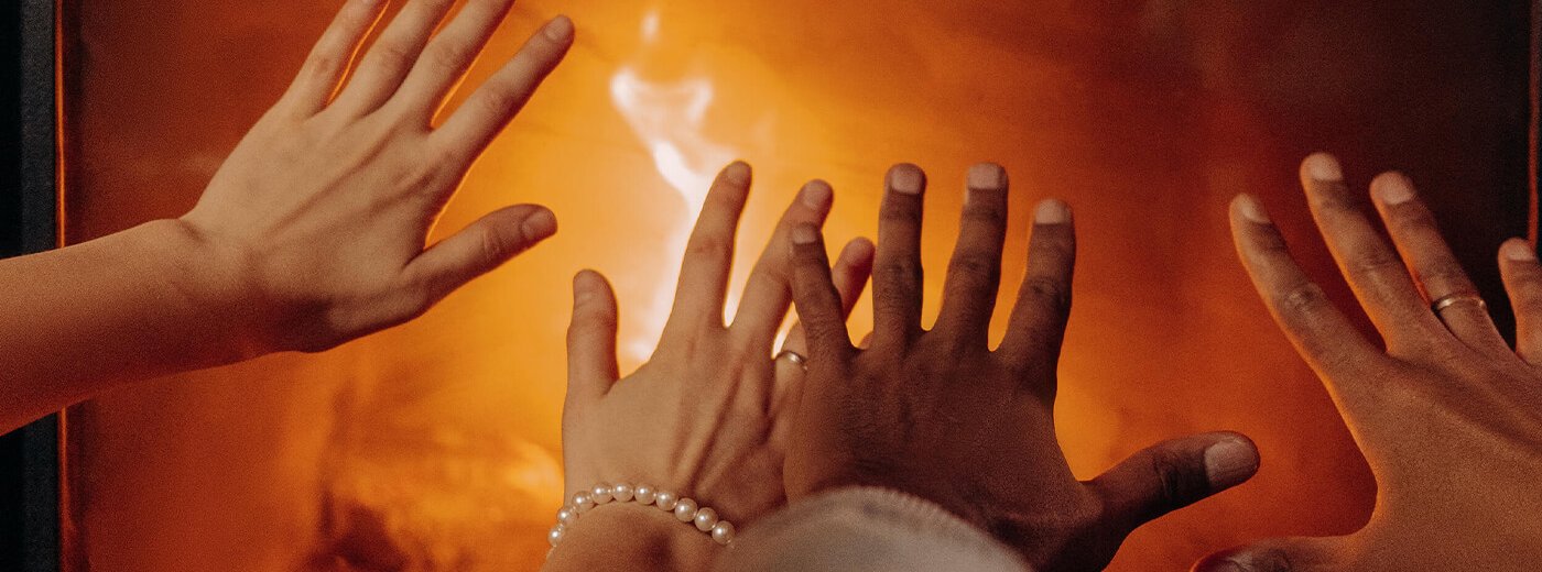 Hands keeping warm by the fireplace