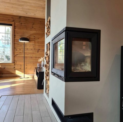 White surround with a black wood insert called Jøtul I 520 FR in a Norwegian cabin.