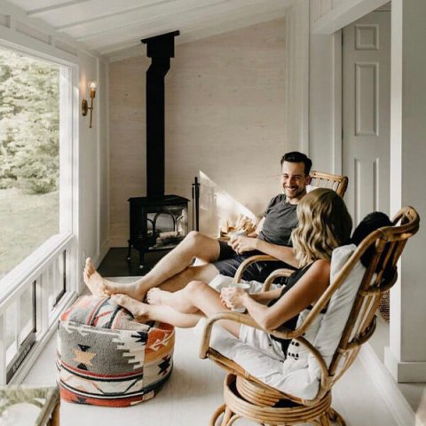 @monettbay woman and man sitting in chairs by the Jøtul F 100 stove.