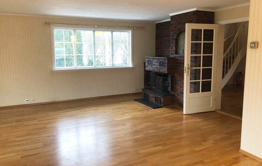 Before-picture of the livingroom with a big fireplace.